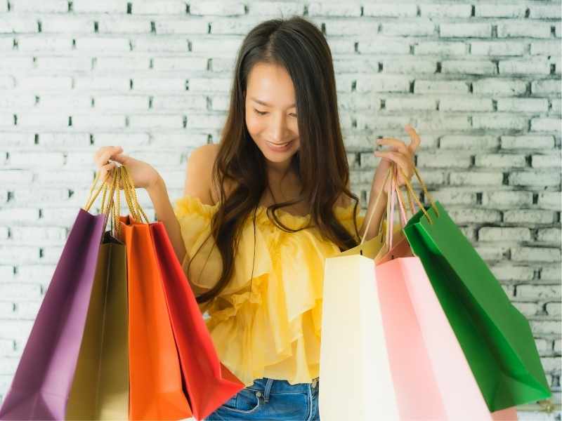mujer muy feliz con muchas bolsas de compra pues cayó en el consumismo del hot sale
